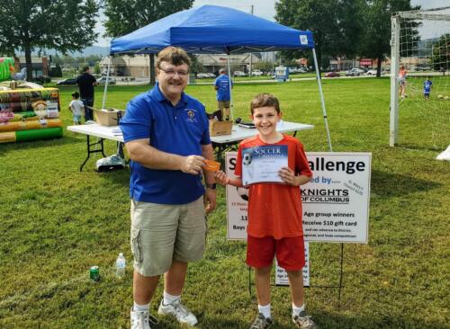 One of the age group winners receiving his certificate and gift card